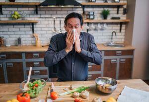 A man covering his mouth, reacting to foods that worsen his sinus problems in St. Peters, MO